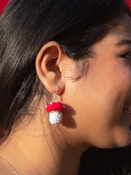 A model wearing the mushroom earrings. They are a subtle but fun way to add some personality to your look.