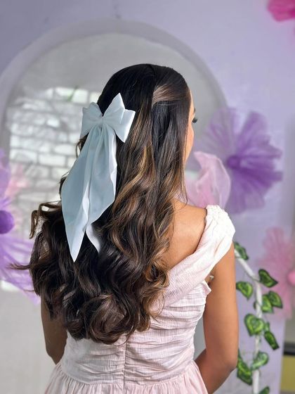 A side angle of the bow hairstyle, showing how it perfectly complements the soft, romantic curls.