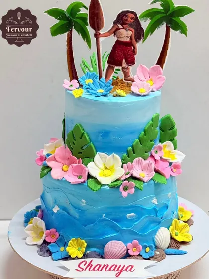 A vibrant Moana theme cake for a tropical birthday party. This two-tier chocolate mousse cake is decorated with ocean waves, tropical flowers, and a Moana topper.