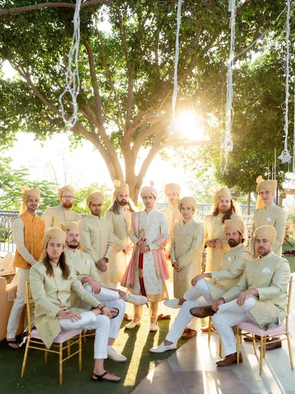 The groom and his groomsmen pose for a cool, sun-kissed group portrait. This photo captures the camaraderie and style of the groom's squad on the big day.