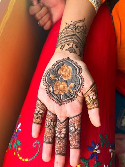 The magic of mehendi. This design features a central floral motif with a unique shaded background, giving it a very artistic look.