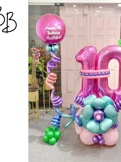 This colorful arrangement for a 10th birthday showcases some fun techniques, like the spiraling balloon coils. The combination of bold pinks and teals with a custom-printed balloon makes it a unique and energetic piece.