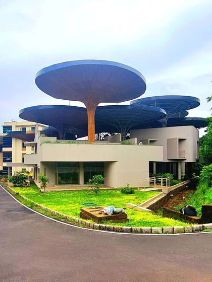 A wider view of the TAPMI Centre nearing completion, with the parasols defining the building's unique silhouette against the sky.