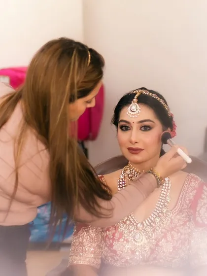 Applying blush to add a healthy flush of color to the bride's cheeks. This is a behind-the-scenes look at my process with a real bride.
