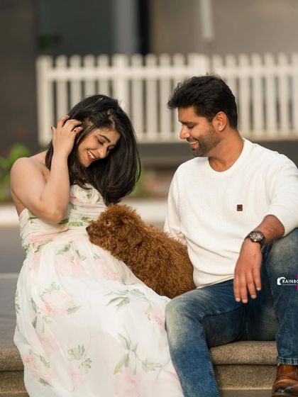 A relaxed and happy photo of the couple sitting together with their furry friend, showcasing a perfect family portrait.