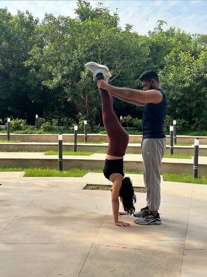 Trust and support are key. Here, Satish helps me practice a handstand, an exercise that builds strength and balance.