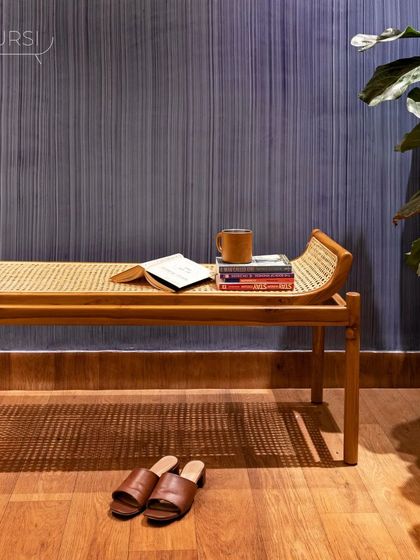 The 'Kyokusen' bench, a perfect spot for a quiet read. The play of texture between the woven rattan, the smooth teak, and the warm wood floor creates a harmonious space.