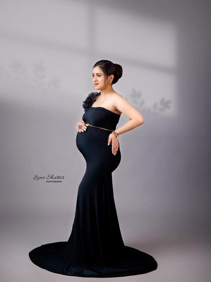 This portrait uses subtle shadows from a window pane to add depth and interest to a classic black gown maternity photo.