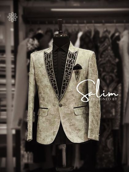 A mannequin showcasing a light-colored printed jacket with a black embroidered lapel. This is a great option for a destination wedding or a summer evening event.