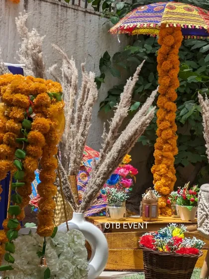 A detailed shot of the props used in our traditional Mehendi decor, featuring marigold garlands, pampas grass, and a hand-painted Rajasthani umbrella.