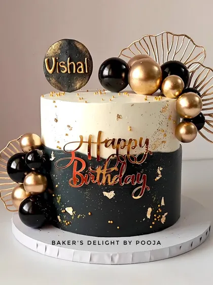 This black and gold cake makes a bold and elegant statement for any milestone celebration. The sophisticated design combines a sharp, two-tone finish with golden spheres and delicate fans, perfect for an extraordinary birthday.