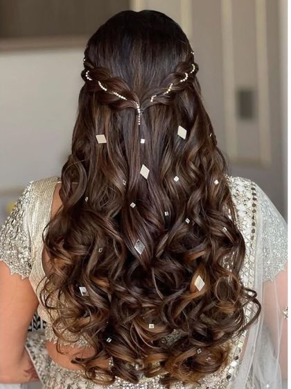 An elegant half-up hairstyle for an engagement party. This look features a twisted braid and voluminous curls, with diamond-shaped accessories for extra sparkle.