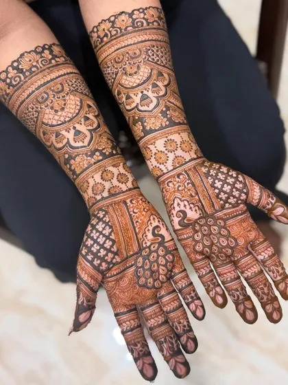 This design combines bold peacocks on the palms with delicate floral bands on the arms. The contrast between the larger motifs and the finer details creates a balanced and beautiful bridal look.