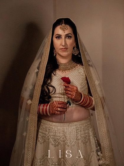 A powerful bridal portrait with her name "LISA" featured. She holds a red rose, looking directly at the camera with a confident and serene expression.