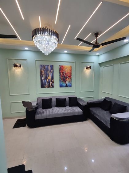 This living room uses a cool mint green paint with classic white wall moulding for a fresh and elegant look. The grand crystal chandelier acts as the stunning focal point of the room.