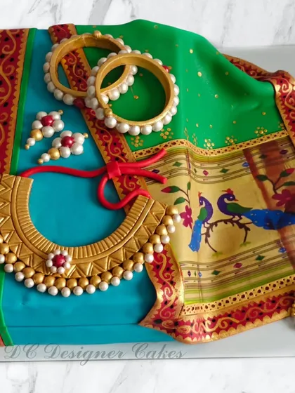 I crafted this hyper-realistic Paithani saree cake to honor a mother's birthday. The design features edible printed fabric, intricate gold jewelry, and traditional bangles, all sculpted from fondant to look just like the real thing.