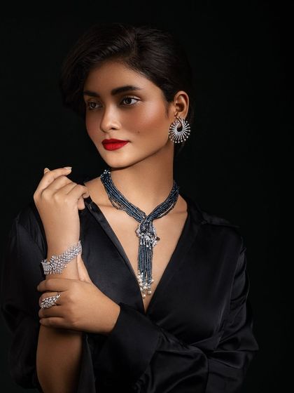This pose highlights the stunning, multi-layered beaded necklace and the matching diamond bracelet.