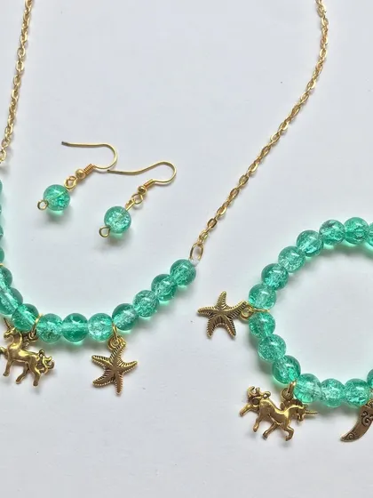 A full view of the green unicorn charm jewellery set, including the necklace, bracelet, and matching drop earrings. This whimsical set is perfect for imaginative kids.