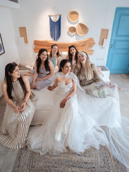 Laughter and joy fill the room as the bride shares a moment with her bridesmaids. This candid photo captures the fun and friendship that are such an important part of the wedding day.