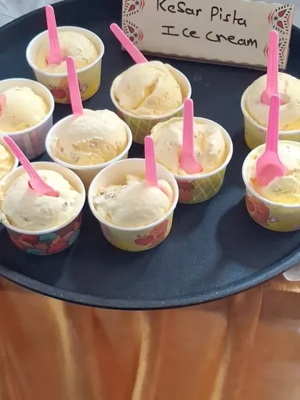 Scoops of delicious Kesar Pista ice cream served in cups, ready to be enjoyed by guests at a wedding.