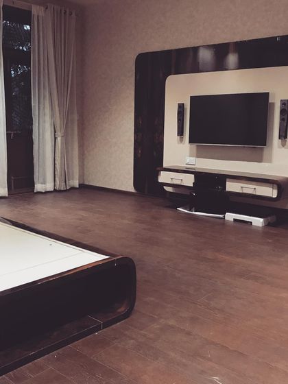 A duplicate shot of the minimalist TV unit, set against a backdrop of wooden flooring and simple curtains.