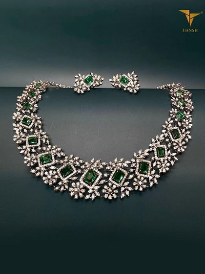 This stunning diamond and emerald creation brings together luxury and tradition. The geometric arrangement of square emeralds and floral diamond clusters is perfect for celebrating in style.