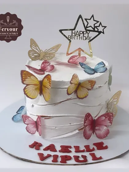 A simple butterfly theme cake with a textured white frosting. This chocolate truffle cake is adorned with colourful, edible wafer paper butterflies.