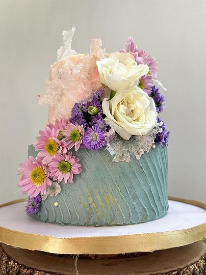 A different perspective of the textured anniversary cake, highlighting the beautiful contrast between the soft peach and cool sage green colours.