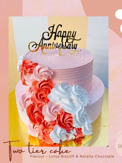 A beautiful two-tier anniversary cake featuring a cascade of red, pink, and white frosting rosettes. This design offers a vibrant and textured look, with Lotus Biscoff and Nutella Chocolate flavors inside.
