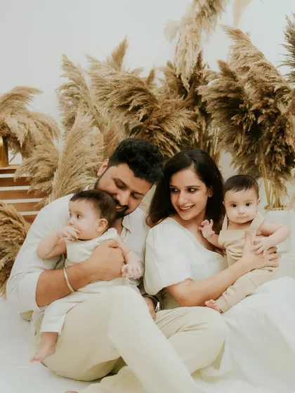A candid moment of parents admiring their twin babies. These are the unscripted moments that tell the real story of your family.