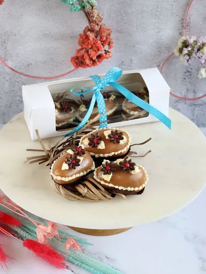 These are my brownie-based Easter eggs. A rich, fudgy brownie is cut into an egg shape and topped with caramel and festive chocolate flowers.