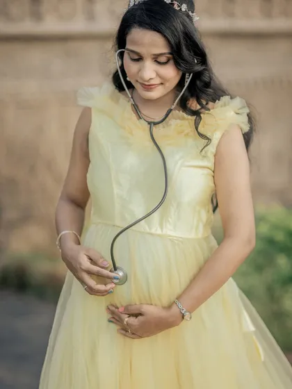 A sweet and creative solo shot, with the mom-to-be listening to her baby bump with a stethoscope.