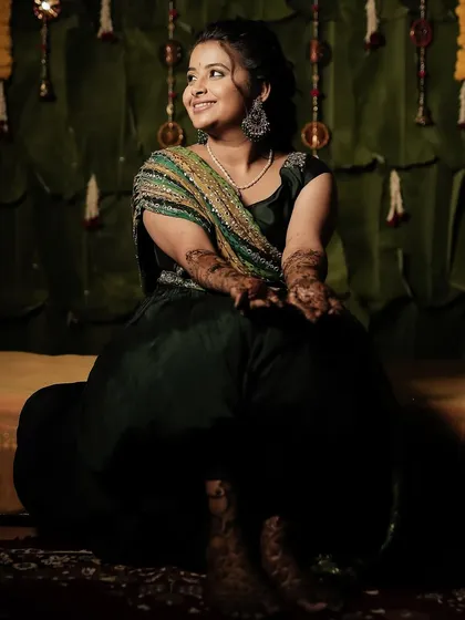 Varshini seated for her Mehendi ceremony, looking relaxed and beautiful.