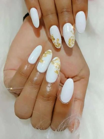 A clean and simple design with white nails and delicate gold foil accents on two fingers.