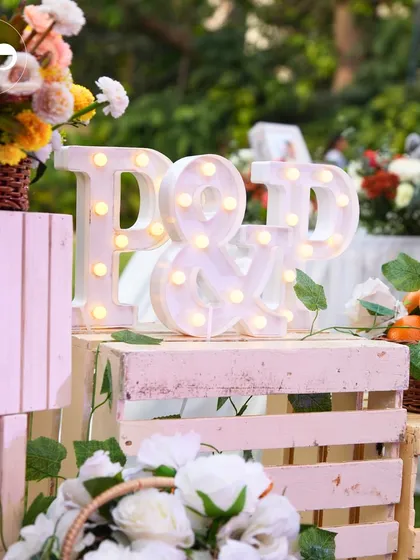Light-up marquee letters with the couple's initials add a personalized and glowing touch to the gift and decor area.