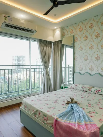 Another angle of the bedroom, showing the interplay of patterns on the wallpaper and bedding.