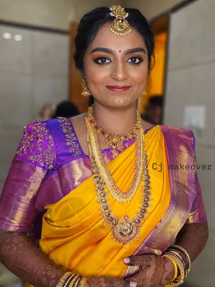 A close-up of the bride's muhurtham makeup. The yellow saree with a purple border is a classic combination, and the makeup complements it perfectly.