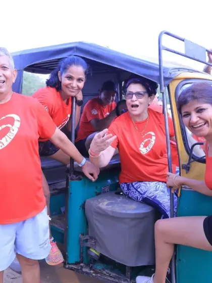 All smiles and fun during a team activity involving an auto-rickshaw. Our fitness challenges are filled with laughter and memorable moments.