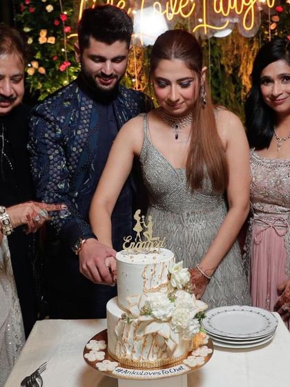 A candid moment of a couple cutting their beautiful two-tiered engagement cake, surrounded by family. It's an honor to be part of such wonderful memories.