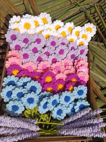 A crate of daisy and lavender stems in a rainbow of colors.