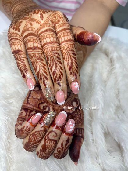 This photo showcases how the complete bridal set comes together. The combination of classic French tips, floral art, and glitter on soft gel extensions creates a look that is both timeless and personal.