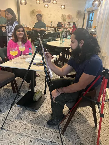 A caricature artist at work in our cafe area, creating a fun portrait for a smiling guest.