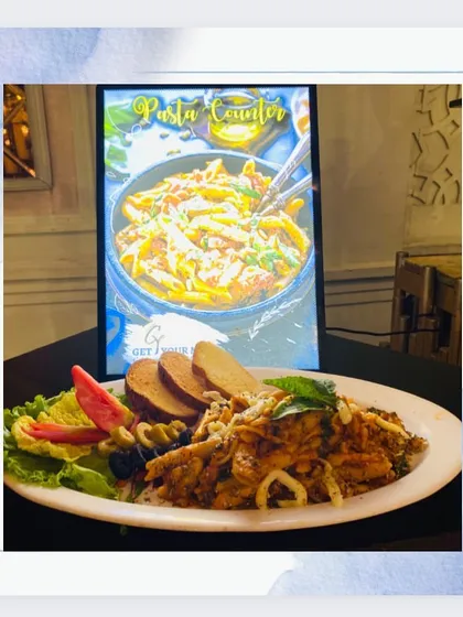A hearty plate of red sauce pasta, served with garlic bread and salad, from our live Italian counter.