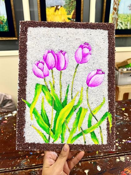 The finished mixed-media tulip painting, where the painted flowers stand out against the textured rice and sand border.