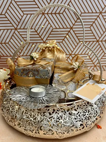 This ornate silver-finish basket is filled with beautifully wrapped gift boxes and a delicate floral T-light holder. It’s a wonderful example of how I balance traditional craftsmanship with modern gifting aesthetics.