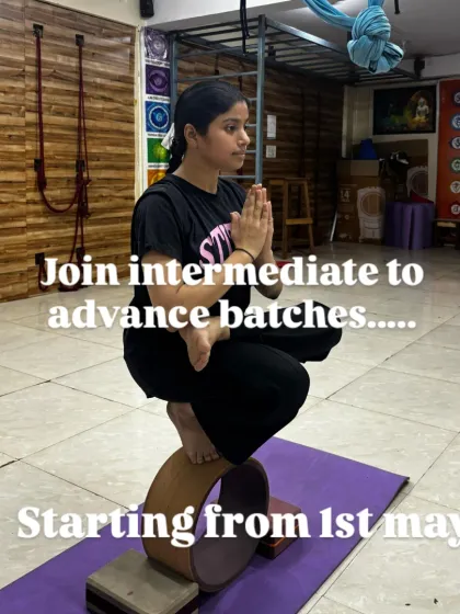 A student demonstrates incredible focus while balancing in Padmasana (Lotus Pose) on a yoga wheel, announcing our intermediate to advanced batches.