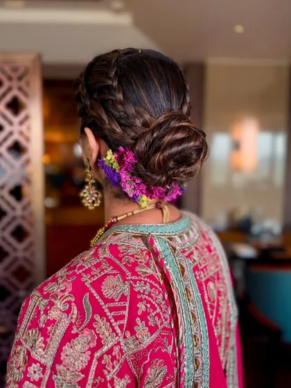 A close-up of this beautiful braided bun. Adorned with fresh, colorful flowers, this hairstyle is perfect for a daytime event like an Anand Karaj or Mehendi.