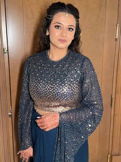 A three-quarter view of the client, ready for her event. The textured waves in her hair and the bold eye makeup create a cohesive and stylish look.