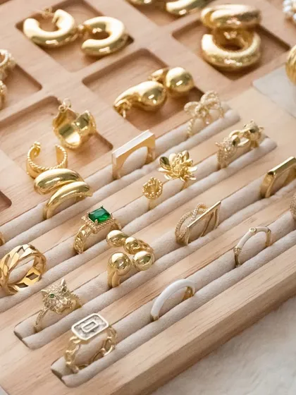 Accessorize like you mean it. A close-up of our wooden jewellery tray, filled with our best-selling rings and earrings.
