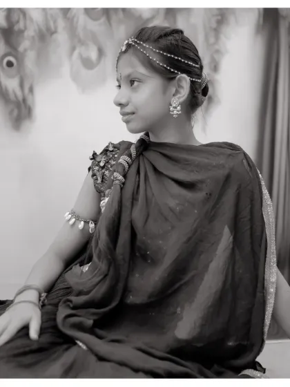 A classic black and white portrait of a young girl in her Radha costume, creating a timeless and artistic image.